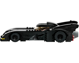 Black LEGO Batmobile, side view, featuring gold cockpit windshield, large rear fins, and a grey exhaust.