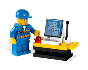 LEGO City minifigure in blue uniform and cap operating a control panel with a computer screen, keyboard, and red button.