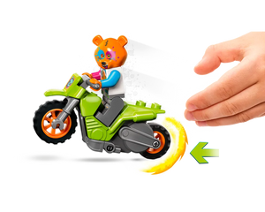 A green LEGO City 60356 Bear Stunt Bike with a bear minifigure, a child's hand, and a pullback motion arrow.