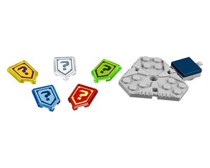 Five translucent LEGO NEXO KNIGHTS shield tiles with question marks (yellow, clear, green, blue, red) and a gray triangular baseplate with dark blue brick.