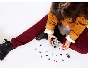 Child assembling LEGO Star Wars 75295 Millennium Falcon Microfighter model with loose bricks and Han Solo minifigure.