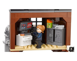 LEGO Arkham Asylum set scene: minifigure at a control desk with 'LOCK DOWN' on monitors, next to an open safe cabinet.