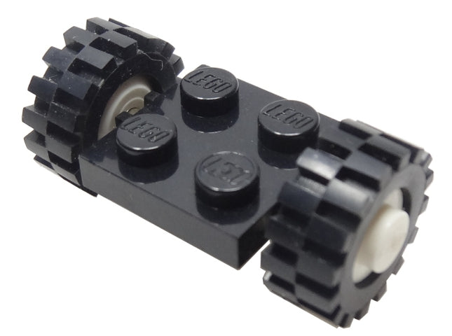 A black LEGO 2x2 modified plate with four studs, attached to two black wheels with offset tread tires and white hubs.