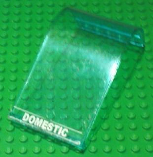 Green transparent LEGO Panel 6 x 6 x 9 Curved Top with white 'DOMESTIC' text and thin lines, on a green studded base.