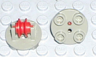 Two light gray LEGO round 2x2 thin plates. One with a red pulley wheel on a holder, the other showing its studded underside.