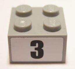 Light gray LEGO 2x2 brick with four studs, featuring a white sticker on its side with a black number 3 in a bold font.