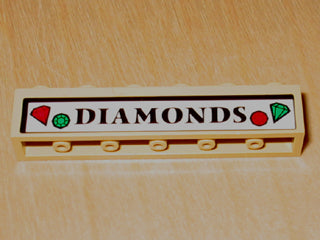 Close-up of a tan LEGO 1x6 brick with a white sticker displaying 'DIAMONDS' in black text, flanked by red and green gem icons.