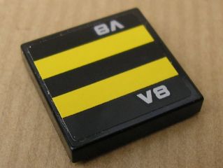 Black LEGO 2x2 tile with two horizontal yellow stripes and silver 'V8' text pattern at top and bottom.