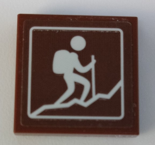 Brown LEGO 2x2 tile with white sign showing a person hiking up a mountain with a backpack and trekking pole.