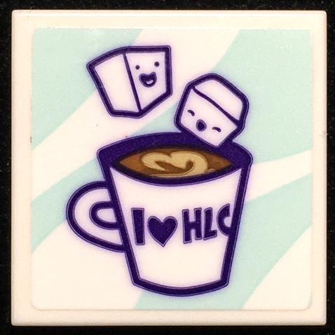 LEGO 2x2 tile with a hot chocolate cup, 'I heart HLC' text, and two smiling marshmallows, on a light blue striped background.