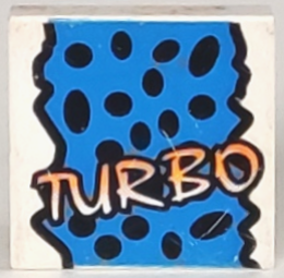 LEGO 3068px22 2x2 tile with yellow 'TURBO' text, black spots, and a jagged blue background pattern.