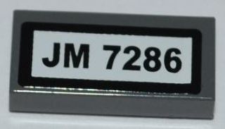 Dark gray LEGO 1x2 tile with a white sticker featuring 'JM 7286' in black text and a black border.