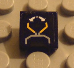 Dark blue LEGO 1x1 tile featuring a yellow crane with a gray base and white circular arrows sticker pattern, on a gray LEGO baseplate.