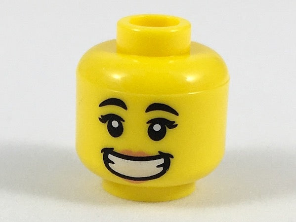 Yellow LEGO minifigure head, female, with black eyebrows, peach lips, and a wide smile showing teeth.