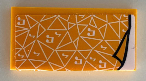 LEGO 2x4 tile, bright light orange with white triangles and music notes pattern. Sticker peeling on right, in yellow holder.