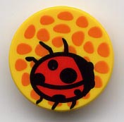 Round 2x2 LEGO tile with a red ladybug on an orange-spotted yellow background.