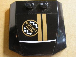 Black LEGO 4x4x2/3 triple curved wedge part 45677pb032 with a 'BULLET RUN' checkered flag logo and two gold stripes pattern sticker.