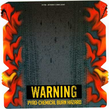 LEGO 61769 plastic ramp cover with a gray-black center, fiery orange-red flames on the sides, and a 'WARNING PYRO-CHEMICAL BURN HAZARD' label.