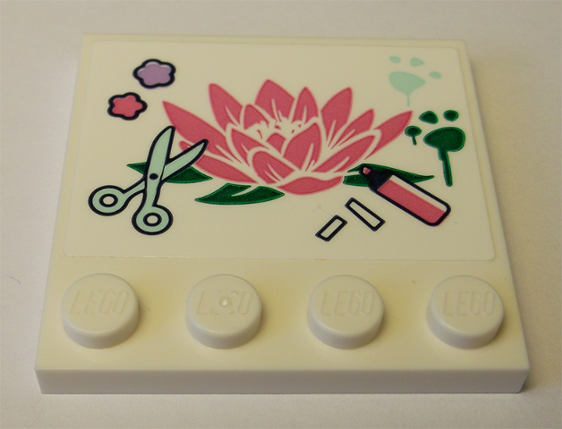 White LEGO 4x4 tile with studs on edge, featuring a pink lotus flower, light green scissors, pink felt pen, and paw prints.