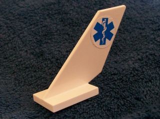White LEGO 6239pb031 Tail Shuttle piece, featuring a circular sticker with a blue Star of Life (EMT) symbol.
