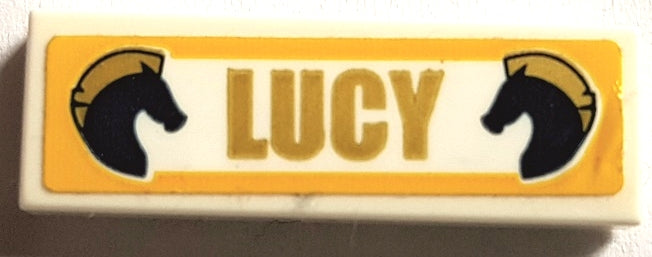 LEGO 1x3 white tile with 'LUCY' and two dark blue horse heads with gold manes on an orange-framed sticker.
