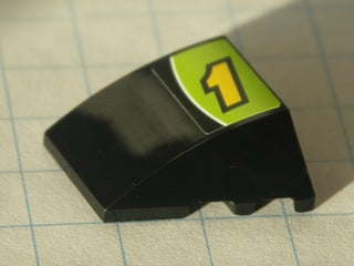 Black LEGO 4x3 triple curved wedge, no studs, with yellow number 1 and white line on lime green background pattern.