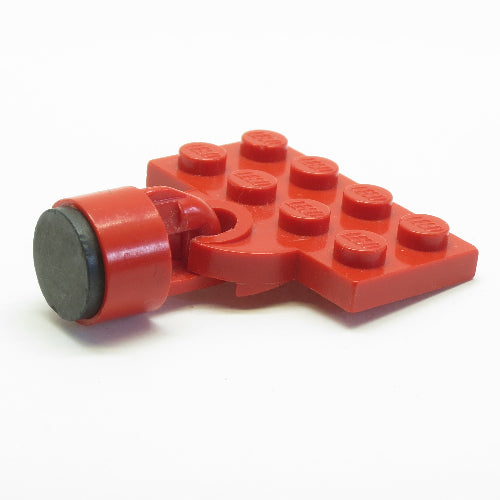 Red LEGO 737ac01 modified 2x4 plate with an open train coupler holding a black 6.5mm magnet for train coupling.
