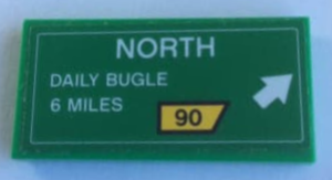 Green LEGO 2x4 tile with a road sign print: NORTH, DAILY BUGLE 6 MILES, a white arrow, and a yellow '90' route marker.