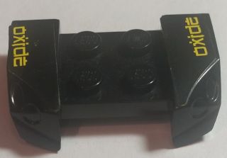Black LEGO 2x4 mudguard piece with headlights overhang, featuring yellow 'oxide' pattern on both sides, from set 8681.