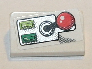 White LEGO 1x2x2/3 slope brick with a sticker depicting a retro-style joystick with a red ball and two green buttons.