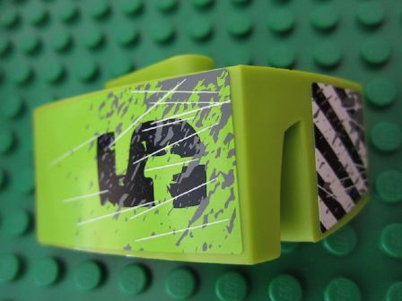 Lime green LEGO Technic car mudguard with black number '5', scratch pattern, and black and white danger stripes on a green baseplate.
