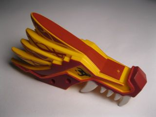 LEGO Ninjago dragon head upper jaw part. Features dark red and yellow sections with red stripe patterns and white teeth.