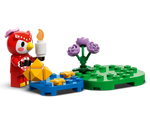 LEGO Animal Crossing Celeste owl figure holds a candle, near a blue base with stars and gold pieces, beside a green base with purple roses.