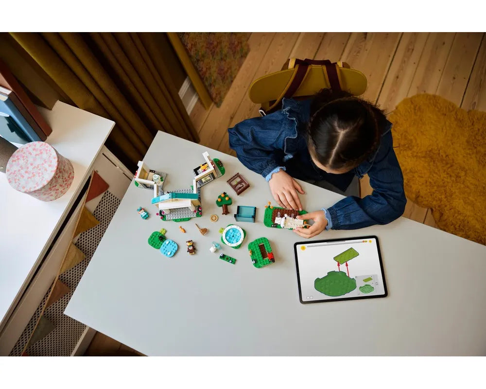 A child building LEGO Animal Crossing Blathers's Museum Collection 77056 with digital instructions on a tablet, surrounded by models.
