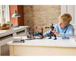 Young boy playing with a large LEGO Giant-Man figure and a LEGO Captain America: Civil War battle scene playset.