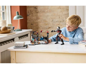 Young boy playing with a large LEGO Giant-Man figure and a LEGO Captain America: Civil War battle scene playset.