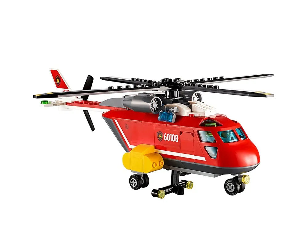 A red LEGO City 60108 Fire Response Unit helicopter with black rotors and yellow water bucket, on a white background.