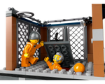 Two LEGO prisoner minifigures in orange jumpsuits escaping. One exits a floor hatch while the other stands nearby.