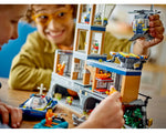 Two children playing with the LEGO City 60419 Police Prison Island set, featuring a multi-story prison, helicopter, and boats.