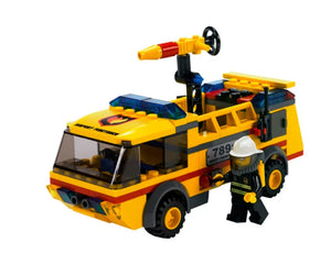 A yellow LEGO City 7891 Airport Firetruck with a rotating water cannon, blue lights, and a firefighter minifigure next to it.