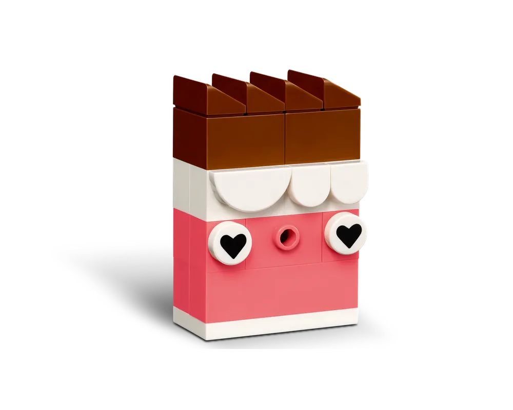 A LEGO brick build resembling a chocolate bar, with a brown top, white middle, and pink base with heart eyes.
