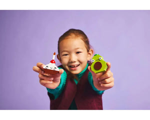 Smiling child holds LEGO cupcake with candle and green avocado from Creative Food Friends set 11039.
