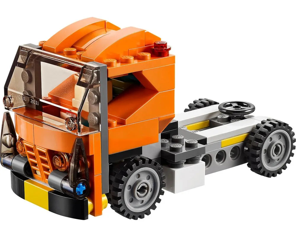 LEGO Creator 31017 orange truck cab and chassis with clear windshield, dark grey wheels, and a black steering wheel.