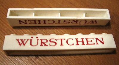 White LEGO 1x8 brick with red 'WÜRSTCHEN' text, split to show the top (with studs) and bottom (with cross supports).
