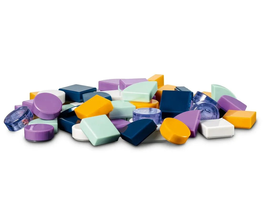 A pile of assorted colorful and clear LEGO DOTS tiles in various shapes: circles, squares, rectangles, and quarter-circles.