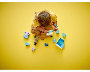 Child playing with LEGO DUPLO 10413 Daily Routines: Bath Time set, holding a bathtub and brush, with blue bricks and animal figures.