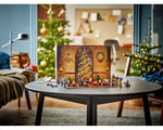 LEGO Harry Potter Advent Calendar 76438 open on a table with mini-builds and minifigures, in a cozy room with Christmas trees.