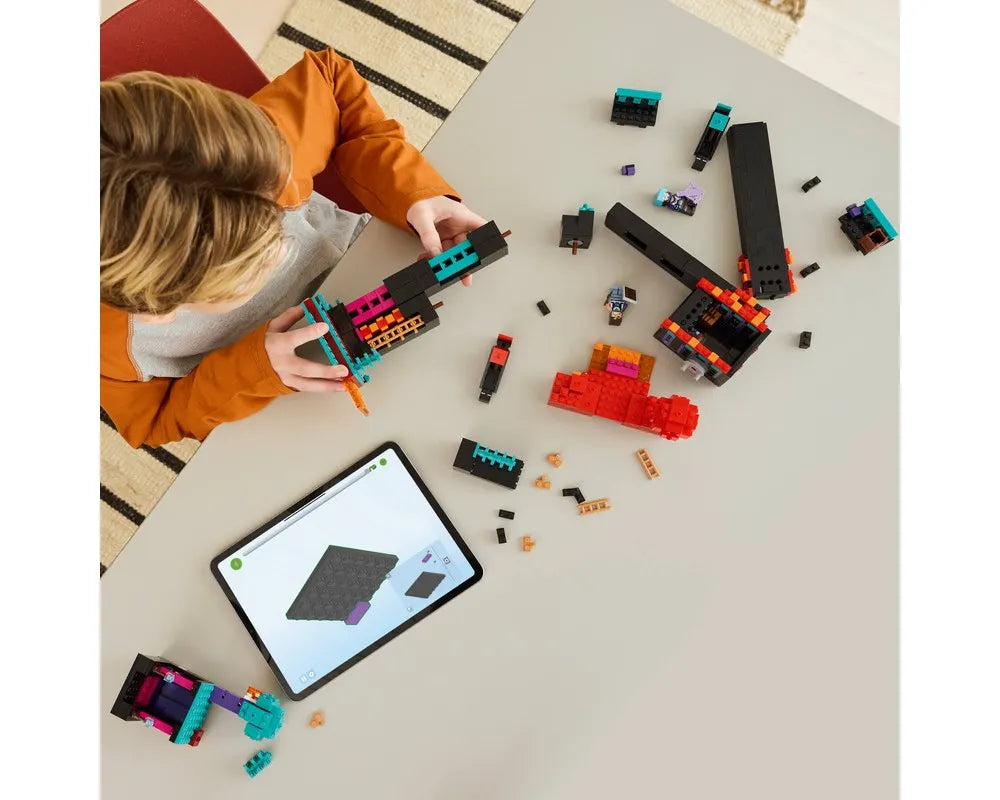 A child building the LEGO Minecraft 21279 The Enderman Tower set with digital instructions on a tablet.