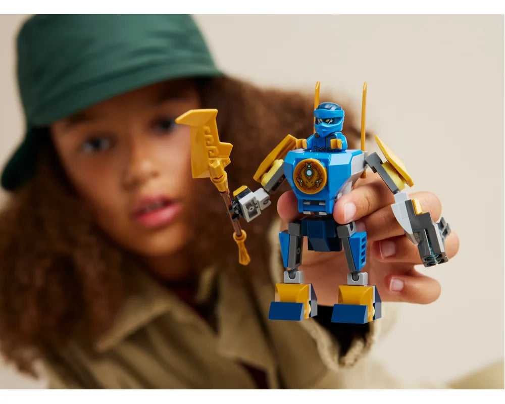 Blue and yellow LEGO Ninjago 71805 Jay's Mech with Jay minifigure, holding golden weapon, held by child.