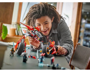 A child plays happily with a red and black LEGO Ninjago 71844 Ninja Combat Vehicle, alongside other Ninjago builds.